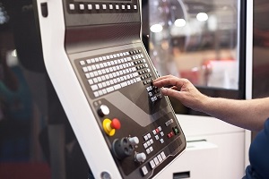 Operator working at programmable CNC machine.