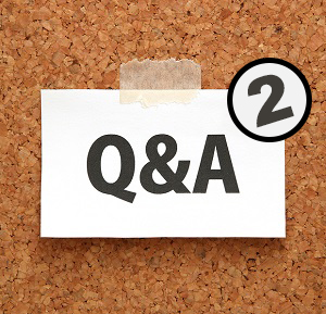 Q&A or Questions and Answers on a piece of white paper on a brown cork board.