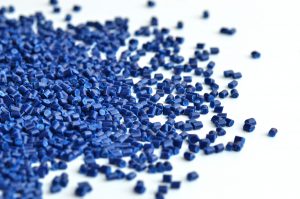 Spill of blue thermoplastic pullets used for plastic injection molding.