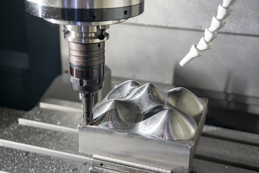 A milling machine modifying an injection mold by trimming steel from the tool.