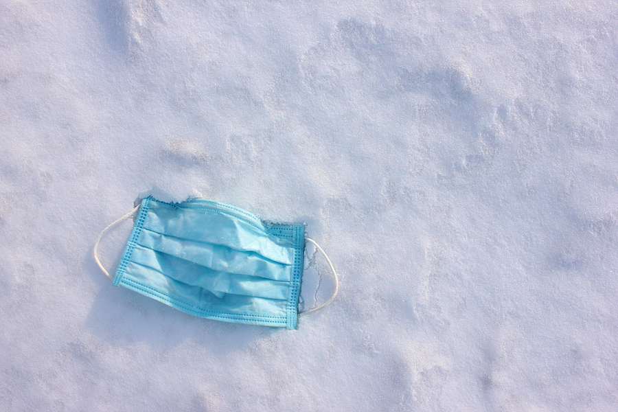 A pandemic face mask discarded on snowy ground to represent the force majeure faced by manufacturers due to a combination of COVID-19 and the Texas snowstorm