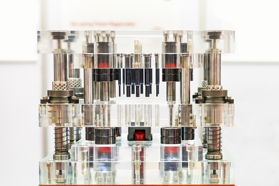 A clear injection mold showing the innerworkings and various components of an ejection system. 