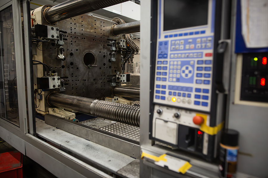 An angular view inside the window of a plastic injection molding machine using a hot runner system with a key pad panel on the right side.