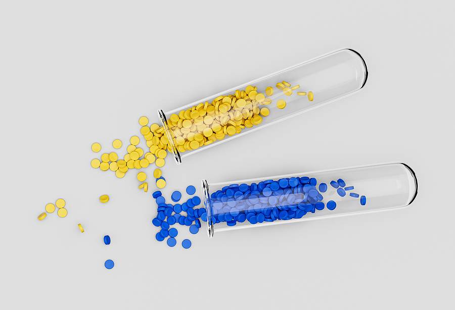 Two test tubes lying on a white surface, one spilling yellow plastic resin and one spilling blue plastic resin.
