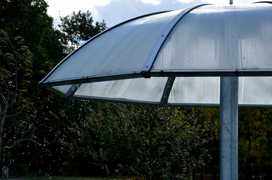 A large parasol in a park made of an impact-resistant thermoplastic called polycarbonate.