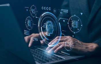 Engineer asking an AI agent on laptop for assistance in designing a part.